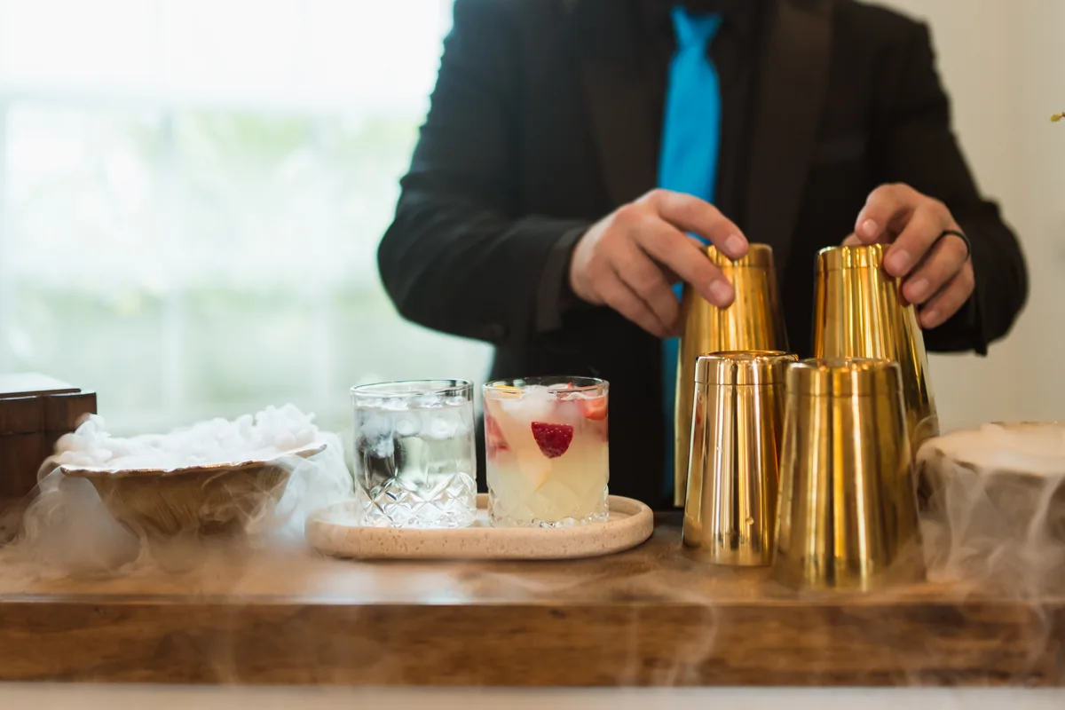 Bartender stacking gold shaker tins